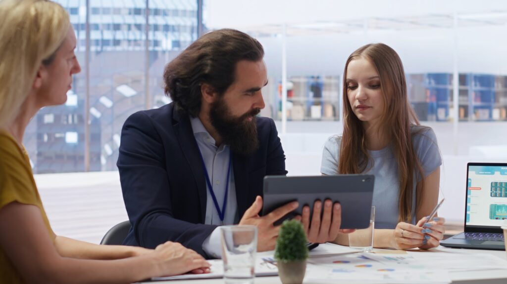 Consultant utilizing financial planning software on tablet to help family
